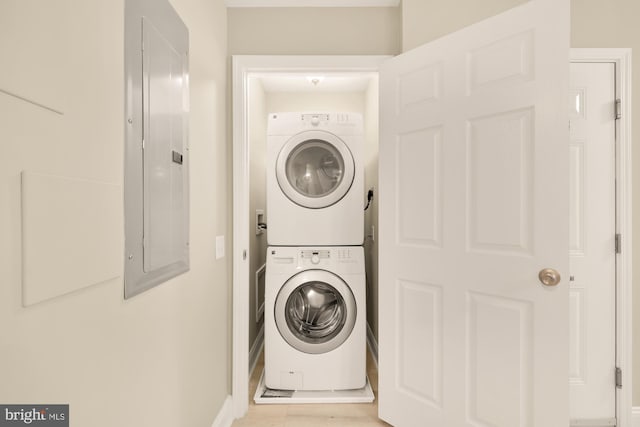 laundry area featuring electric panel, laundry area, and stacked washer and clothes dryer