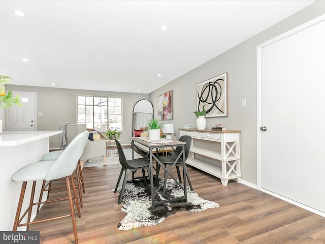 dining space with baseboards, wood finished floors, and recessed lighting