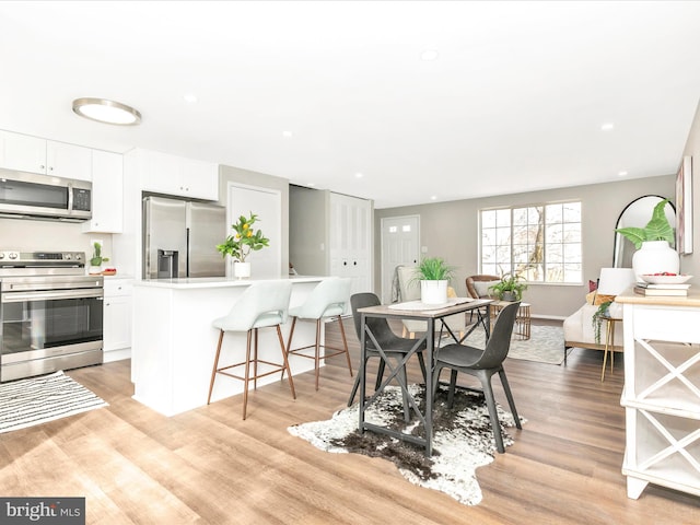 dining space featuring recessed lighting, light wood-style flooring, and baseboards