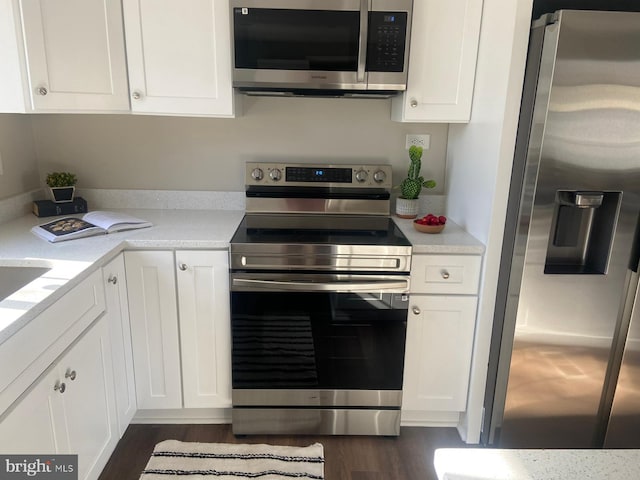 kitchen featuring stainless steel appliances, light countertops, and white cabinetry