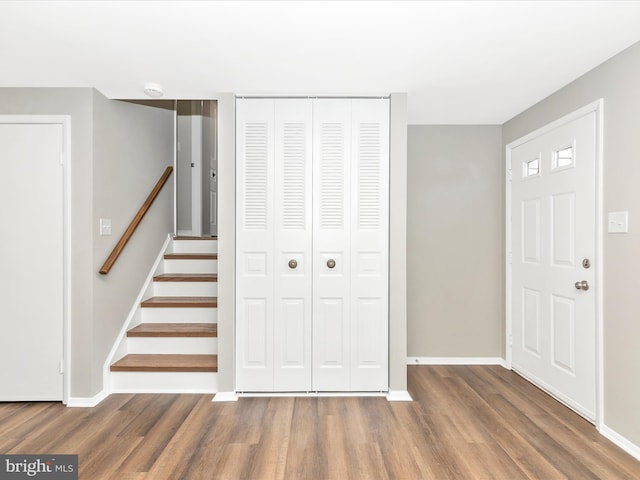 entrance foyer with stairway, baseboards, and wood finished floors