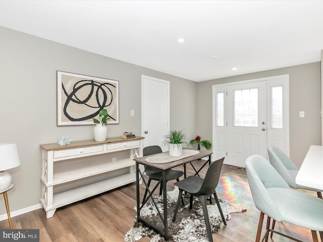 dining space with baseboards, wood finished floors, and recessed lighting