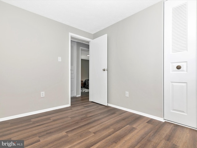 unfurnished bedroom with wood finished floors and baseboards