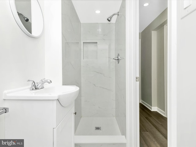 full bath featuring recessed lighting, a marble finish shower, wood finished floors, and vanity