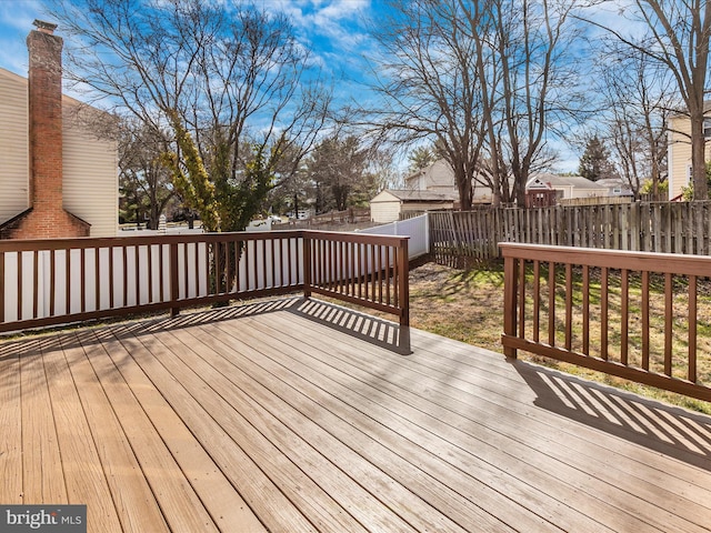 wooden terrace with a fenced backyard