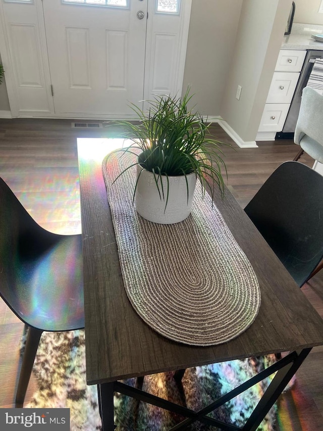 dining space with dark wood-style flooring and baseboards