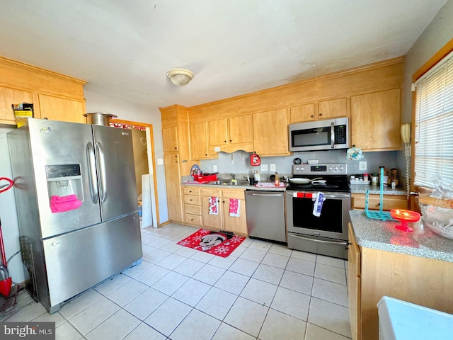 kitchen featuring appliances with stainless steel finishes, light countertops, and light tile patterned flooring