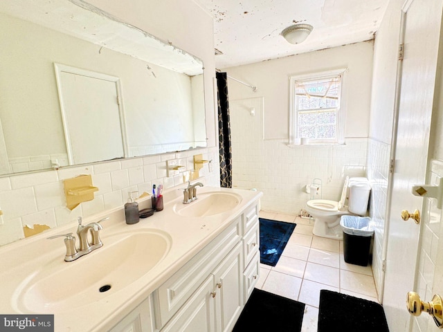 full bathroom featuring double vanity, tile patterned flooring, toilet, and a sink