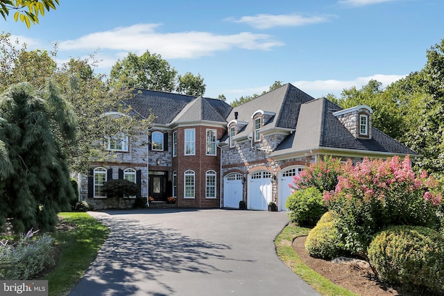 french country inspired facade with aphalt driveway, a high end roof, and stone siding