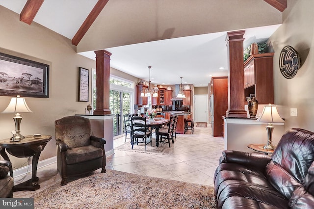 living room with light tile patterned floors, baseboards, decorative columns, and vaulted ceiling with beams