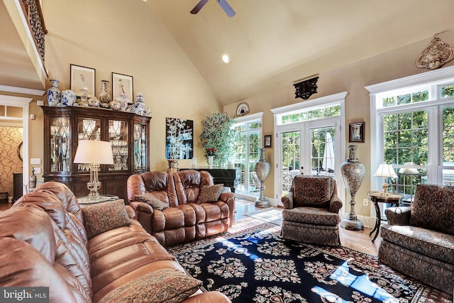 living area featuring high vaulted ceiling, wood finished floors, a ceiling fan, baseboards, and french doors