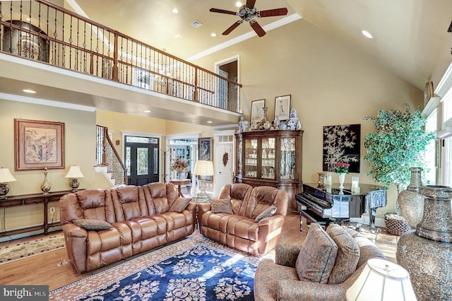 living room with a high ceiling, wood finished floors, and crown molding