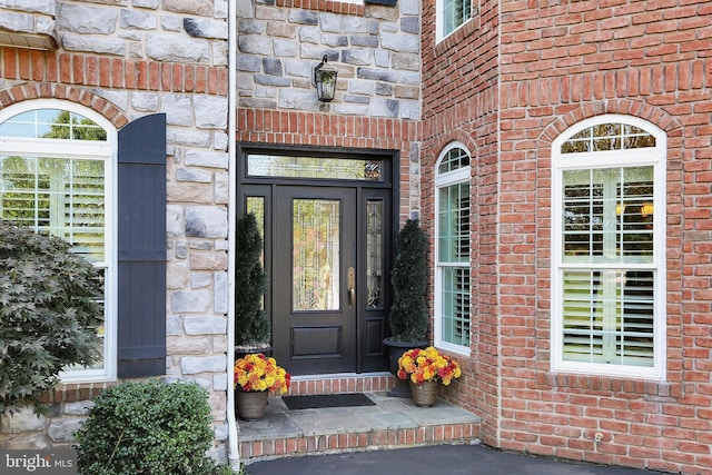 doorway to property with stone siding and brick siding