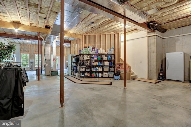 basement with stairway and freestanding refrigerator