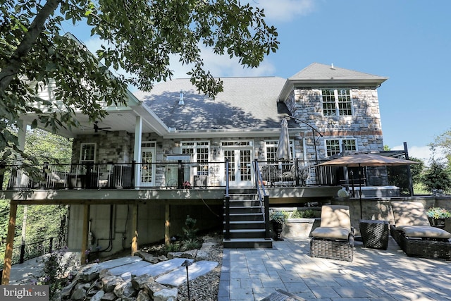 rear view of house with a patio, stone siding, french doors, stairway, and a wooden deck