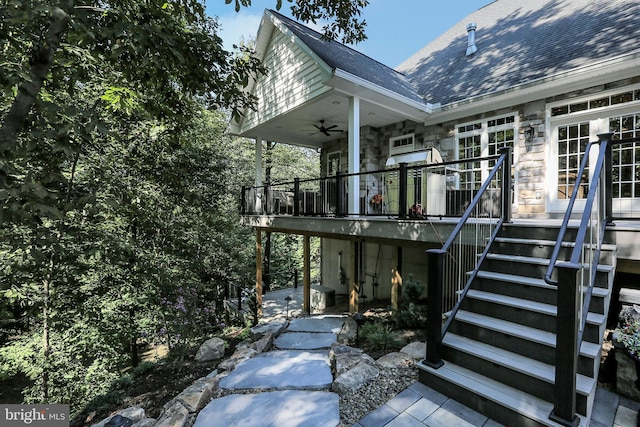 exterior space featuring stone siding, stairway, and a ceiling fan