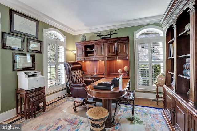 home office featuring crown molding, light wood finished floors, and baseboards