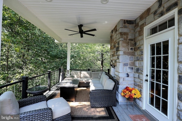 wooden terrace featuring ceiling fan and an outdoor living space