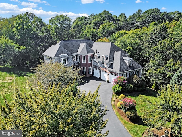 bird's eye view with a wooded view