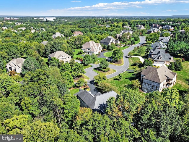 drone / aerial view featuring a forest view and a residential view