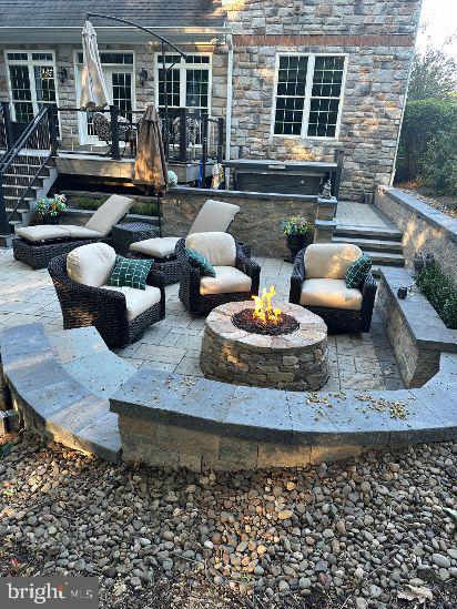 view of patio / terrace featuring an outdoor fire pit and stairs