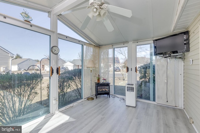 unfurnished sunroom with a ceiling fan and vaulted ceiling with beams