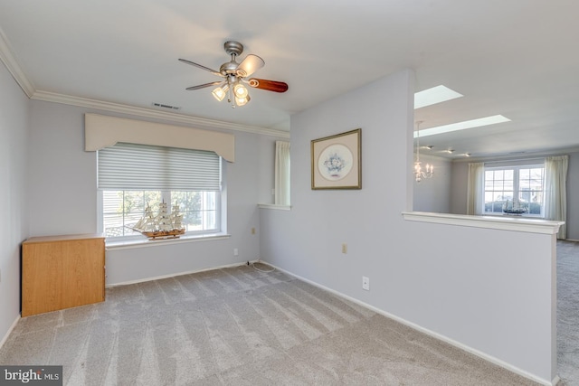 spare room with ornamental molding, a wealth of natural light, and light colored carpet