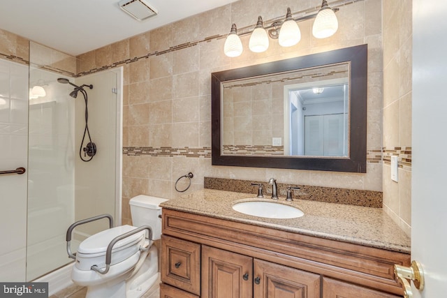 full bath with toilet, visible vents, vanity, tile walls, and a stall shower