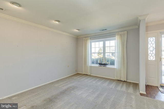 empty room with baseboards, ornamental molding, visible vents, and a healthy amount of sunlight