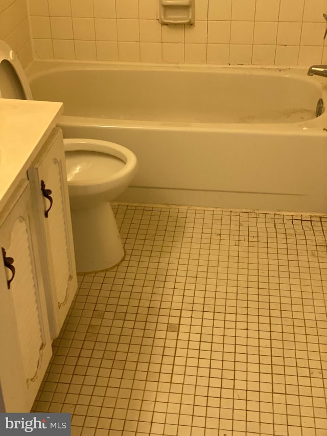 full bathroom featuring a tub, tile patterned flooring, vanity, and toilet