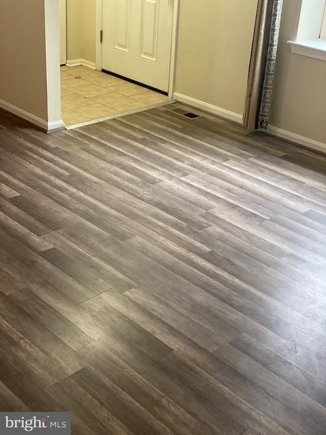 unfurnished bedroom featuring dark wood-type flooring, visible vents, and baseboards