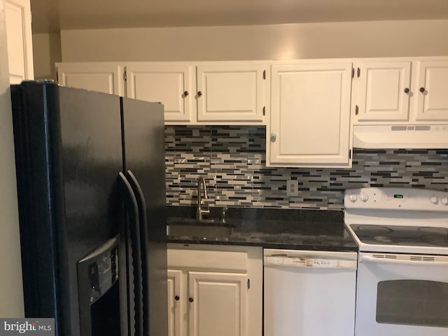 kitchen with dark countertops, white cabinets, a sink, white appliances, and under cabinet range hood