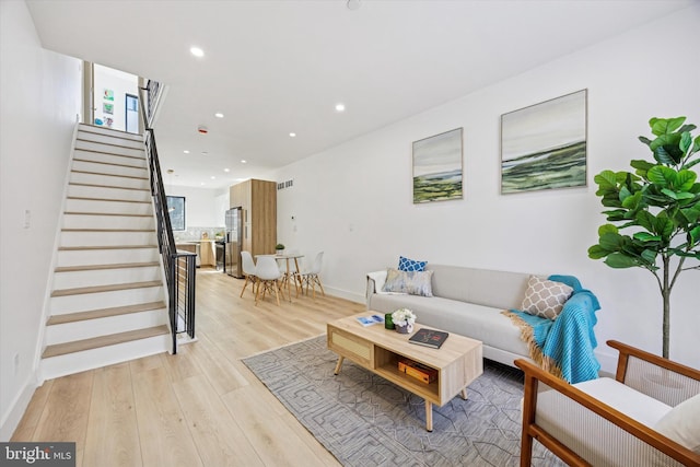 living room with visible vents, light wood-style flooring, recessed lighting, stairway, and baseboards