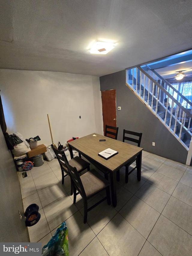 tiled dining room featuring stairs