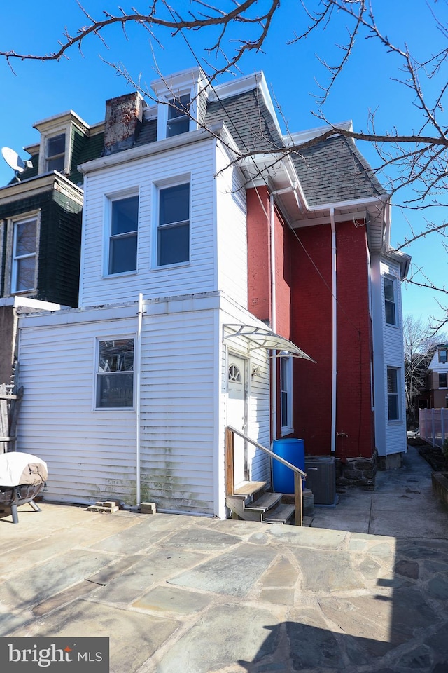 rear view of house with entry steps, a patio area, and cooling unit