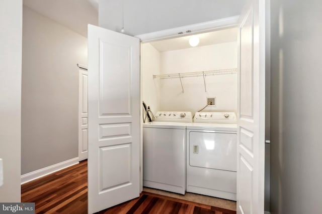 washroom featuring laundry area, washing machine and clothes dryer, dark wood finished floors, and baseboards