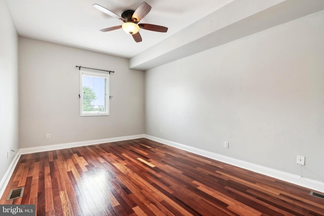 spare room with visible vents, baseboards, and wood finished floors