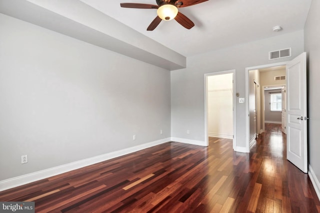 unfurnished bedroom with ceiling fan, dark wood-type flooring, visible vents, and baseboards