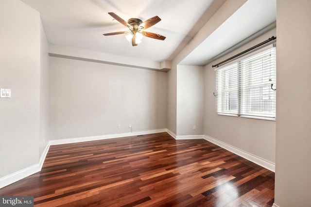 spare room with wood finished floors, a ceiling fan, and baseboards