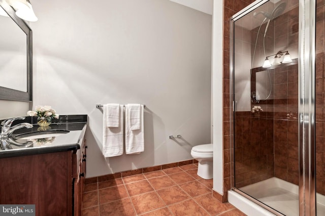 full bath with toilet, a shower stall, vanity, tile patterned flooring, and baseboards