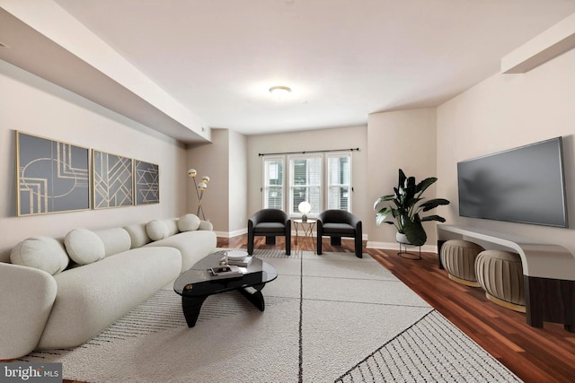 living area with baseboards and wood finished floors