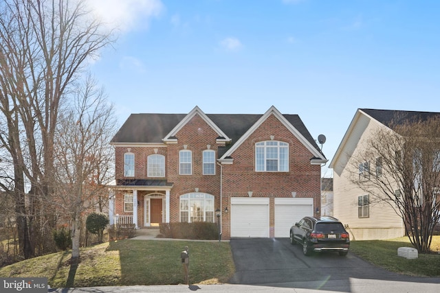 view of front of home with brick siding, a front yard, an attached garage, and aphalt driveway