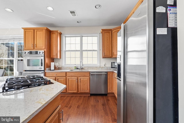 kitchen with recessed lighting, dark wood-style flooring, a sink, visible vents, and appliances with stainless steel finishes