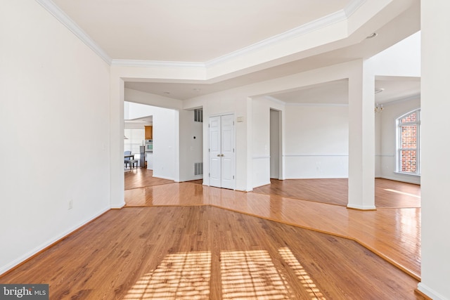 interior space featuring visible vents, crown molding, light wood-style flooring, and baseboards