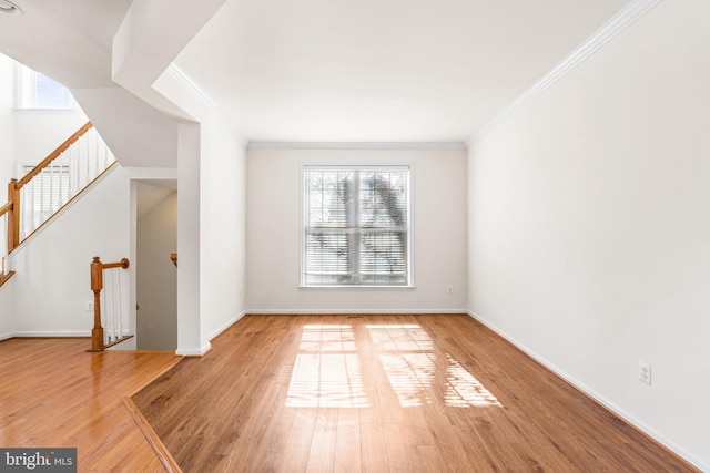 interior space with crown molding, baseboards, and wood finished floors