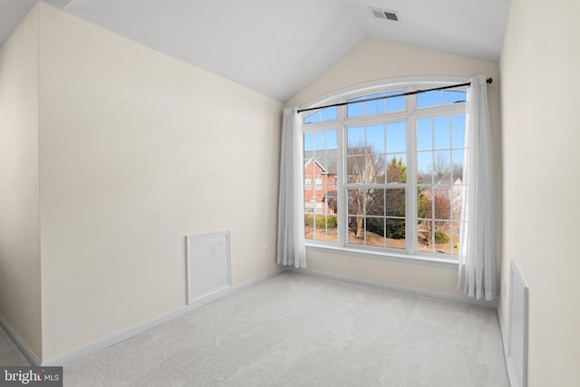 unfurnished room with lofted ceiling, carpet flooring, visible vents, and baseboards