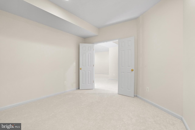 empty room with baseboards and light colored carpet