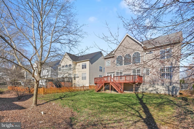 rear view of house with stairs, fence, a deck, and a lawn