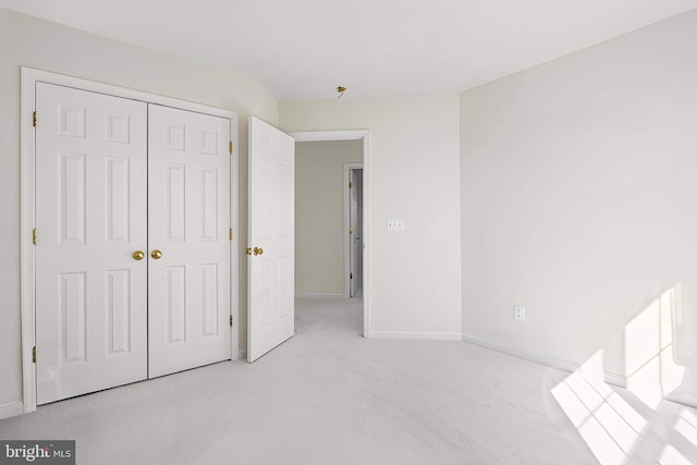 unfurnished bedroom with a closet and baseboards