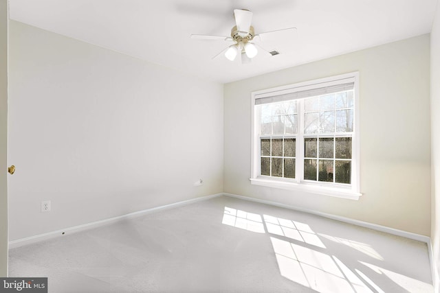 empty room with visible vents, carpet flooring, a ceiling fan, and baseboards